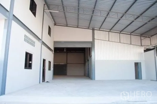 Warehouse for rent in Bang Phli, Samut Prakan - Covered loading bay with high roof, roller shutter, and attached office windows.