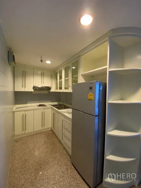 คอนโด ให้เช่าในWatthana, Bangkok - ครัวแบบแกเล่ย์ขนาดกะทัดรัด ตู้สีขาว ชั้นวางของ และตู้เย็นสแตนเลส
