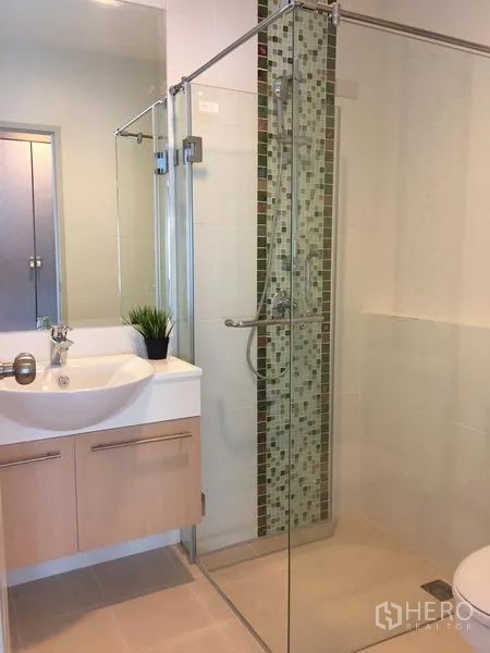 Detached House for rent or sale in Saphan Sung, Bangkok - Clean bathroom with frameless glass shower and vertical mosaic strip.