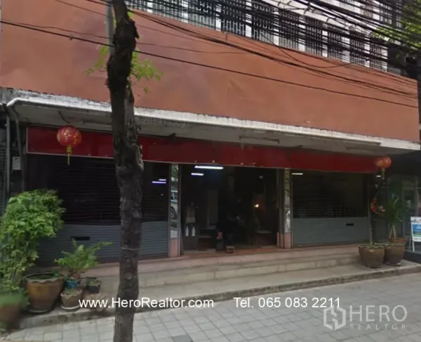 零售空间 出租在Phra Khanong, Bangkok - 曼谷帕卡侬街边零售店铺，宽玻璃门面、卷帘门与遮棚，台阶连接人行道，临近BTS Punnawithi。