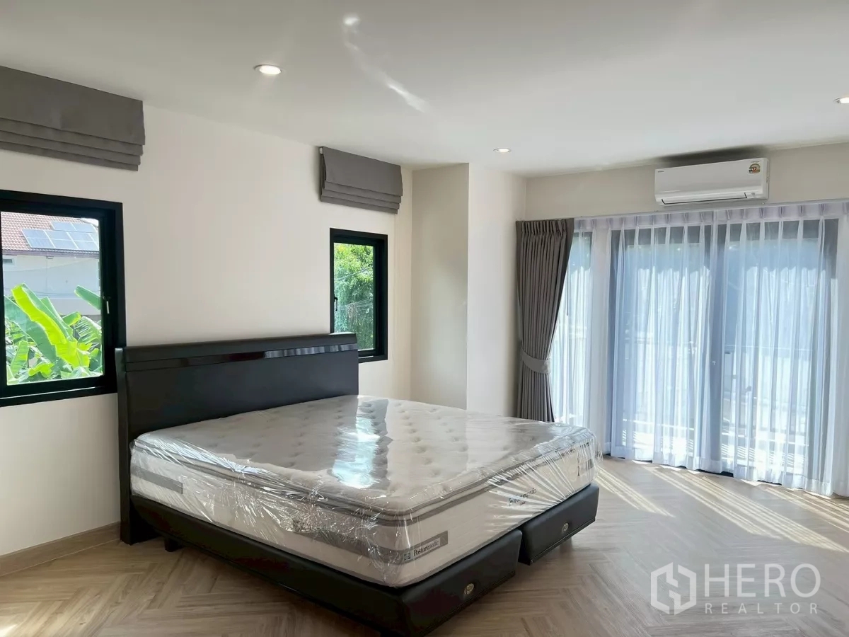 บ้าน ให้เช่าในSuan Luang, Bangkok - รายละเอียดห้องนอนมาสเตอร์ มีหน้าต่างบานใหญ่ ผ้าม่าน และเครื่องปรับอากาศ.