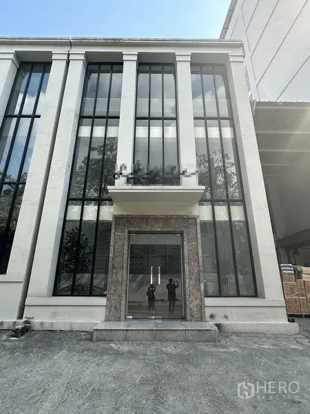 สำนักงานที่บ้าน ให้เช่าในPhra Khanong, Bangkok - ด้านหน้าอาคารโฮมออฟฟิศสมัยใหม่ พร้อมกระจกแนวตั้งสูงและประตูกระจก