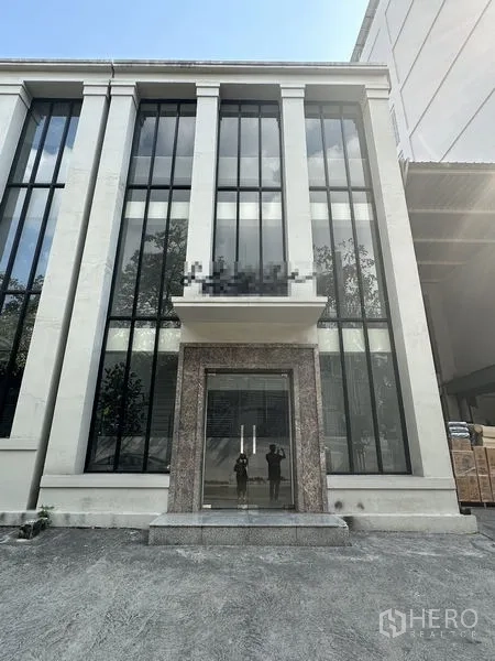 สำนักงานที่บ้าน ให้เช่าในPhra Khanong, Bangkok - ด้านหน้าอาคารโฮมออฟฟิศสมัยใหม่ พร้อมกระจกแนวตั้งสูงและประตูกระจก