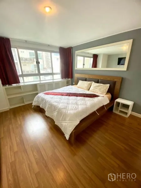 公寓 出租在Watthana, Bangkok - 宽敞卧室，木地板、双人床、超大墙面镜与宽窗。