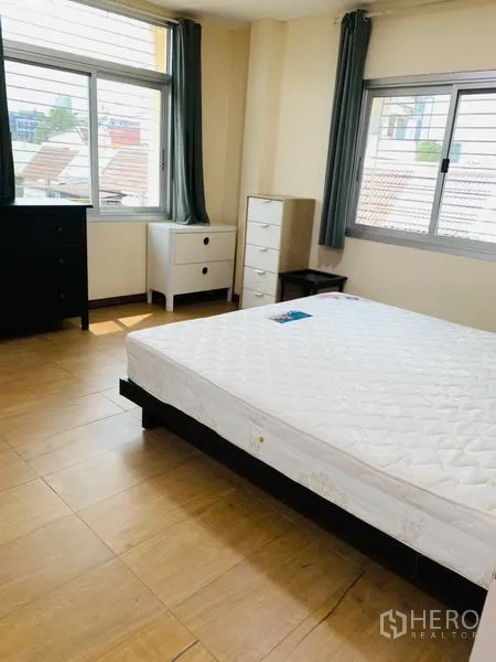 联排别墅 出租或出售在Huai Khwang, Bangkok - 主卧室，大窗与浅木地板，配大床与多组抽屉柜