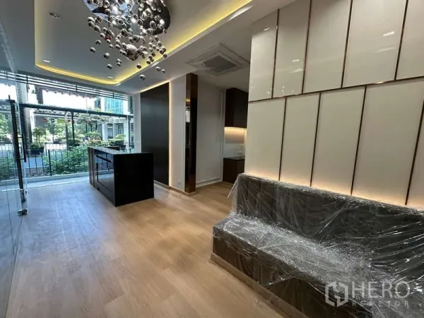 สำนักงาน ให้เช่า - พื้นที่ต้อนรับพร้อมโคมไฟดีไซน์ ม้านั่งบุนวม และผนังกระจกมองเห็นสวน