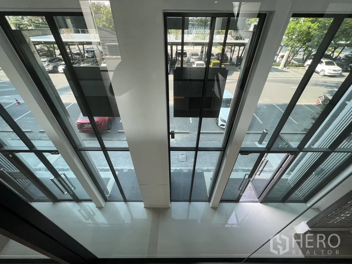 สำนักงานที่บ้าน ให้เช่าในBang Phli, Samut Prakan - มุมมองจากชั้นลอยลงสู่ประตูกระจกเต็มความสูงและลานจอดรถด้านหน้า