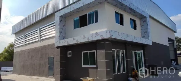 คลังสินค้า ให้เช่าในBang Khun Thian, Bangkok - มุมเอียงอาคารโกดังพร้อมช่องหน้าต่างออฟฟิศ บานเกล็ดระบายอากาศ และหลังคาเมทัลชีท