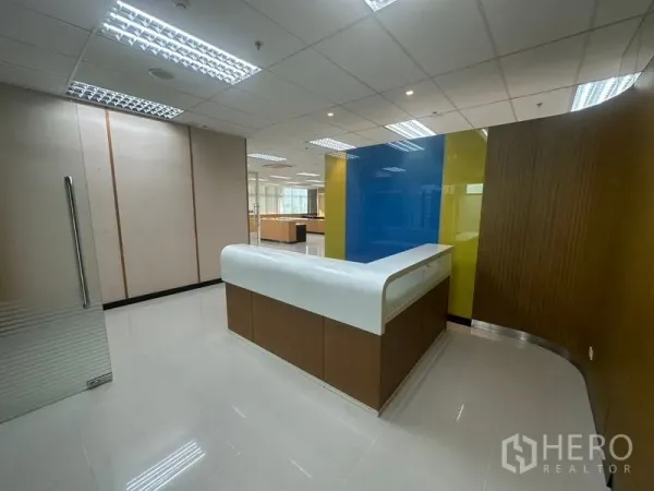 办公空间 出租在Suan Luang, Bangkok - 接待区，弧形前台、亮面地砖与彩色墙面。