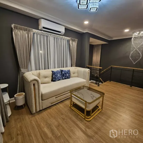 Detached House for rent in Bang Phli, Samut Prakan - Upstairs family lounge with sofa, coffee table, wood flooring, dark accent walls and air conditioning.