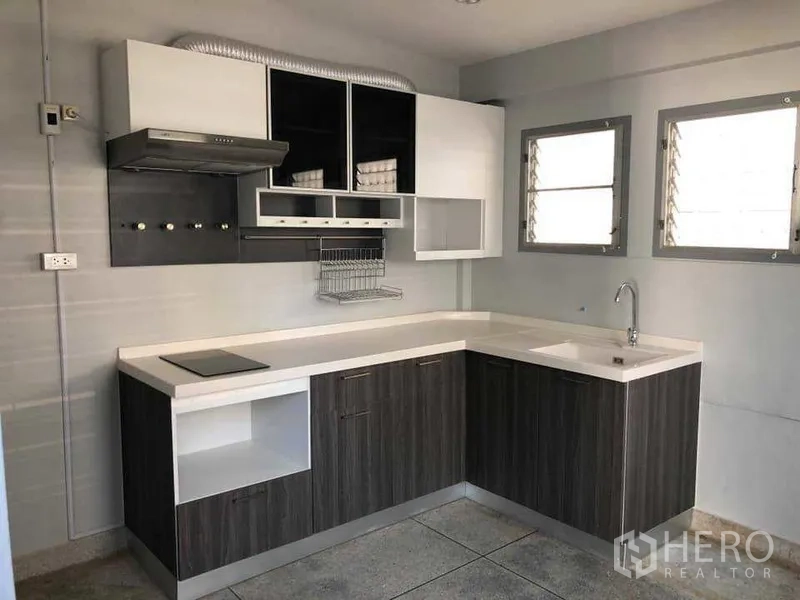 บ้าน ให้เช่าในPhra Khanong, Bangkok - ครัวบิลท์อินรูปตัวแอล เคาน์เตอร์สีขาว เตาและเครื่องดูดควัน