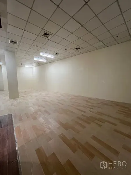 零售空间 出租在Watthana, Bangkok - 狭长矩形店内空间，吊顶与暖色木纹地砖。