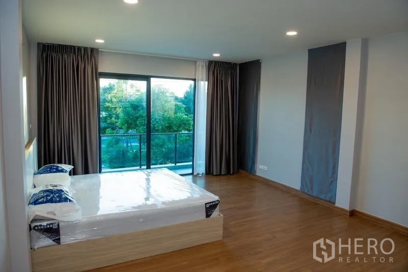 Detached House for rent in Bang Phli, Samut Prakan - Large bedroom with bed and sliding glass doors to a balcony with greenery views.