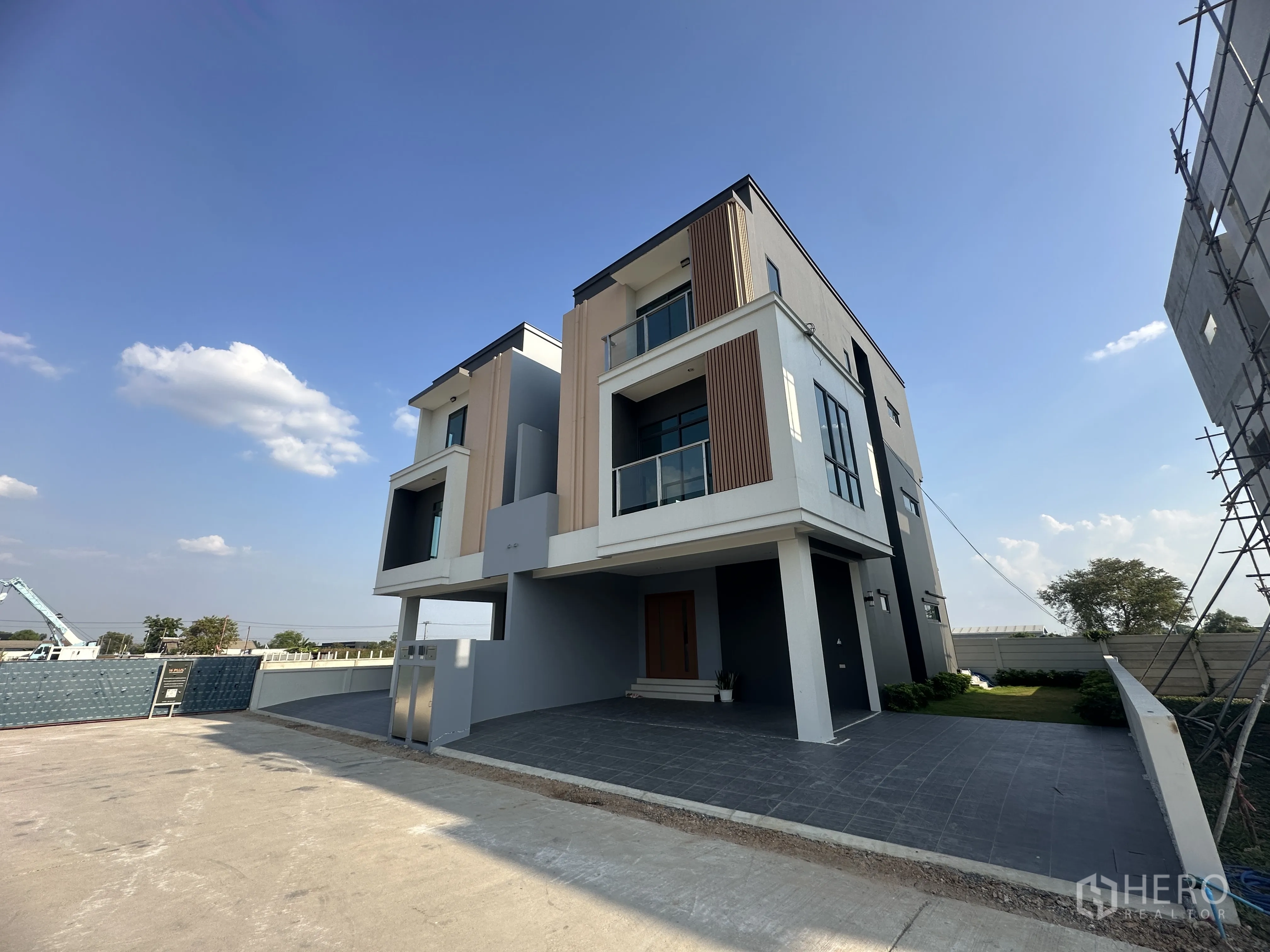 Home Office for sale in Khlong Luang, Pathum Thani - Modern three-storey home office exterior with balconies, driveway, and a small lawn.