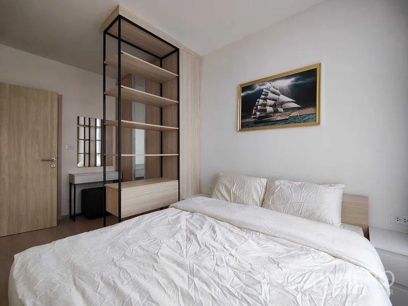 Condominium for rent - Master bedroom showing open shelving divider, built-in wardrobe and vanity.