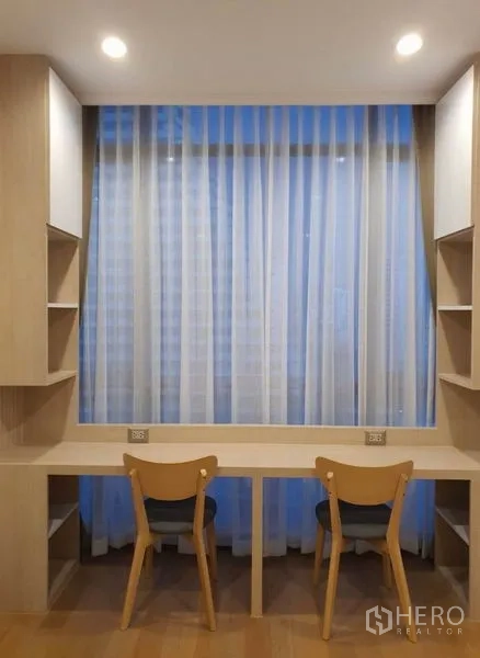 คอนโด ให้เช่าในWatthana, Bangkok - มุมทำงานคู่พร้อมชั้นวางของและโต๊ะทำงานสองที่นั่งใต้ผ้าม่านโปร่ง