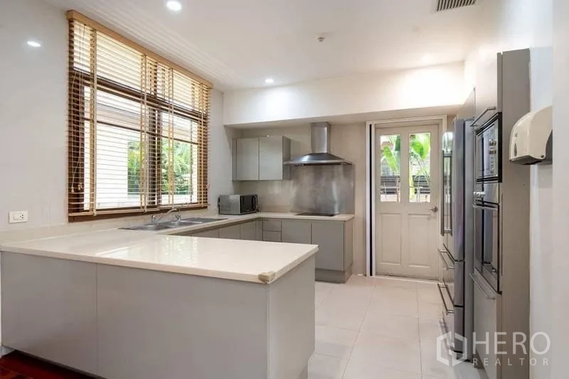 บ้าน ให้เช่าหรือขายในWatthana, Bangkok - ห้องครัวสว่าง เคาน์เตอร์หินสีขาว ตู้เทา เครื่องดูดควันสแตนเลส