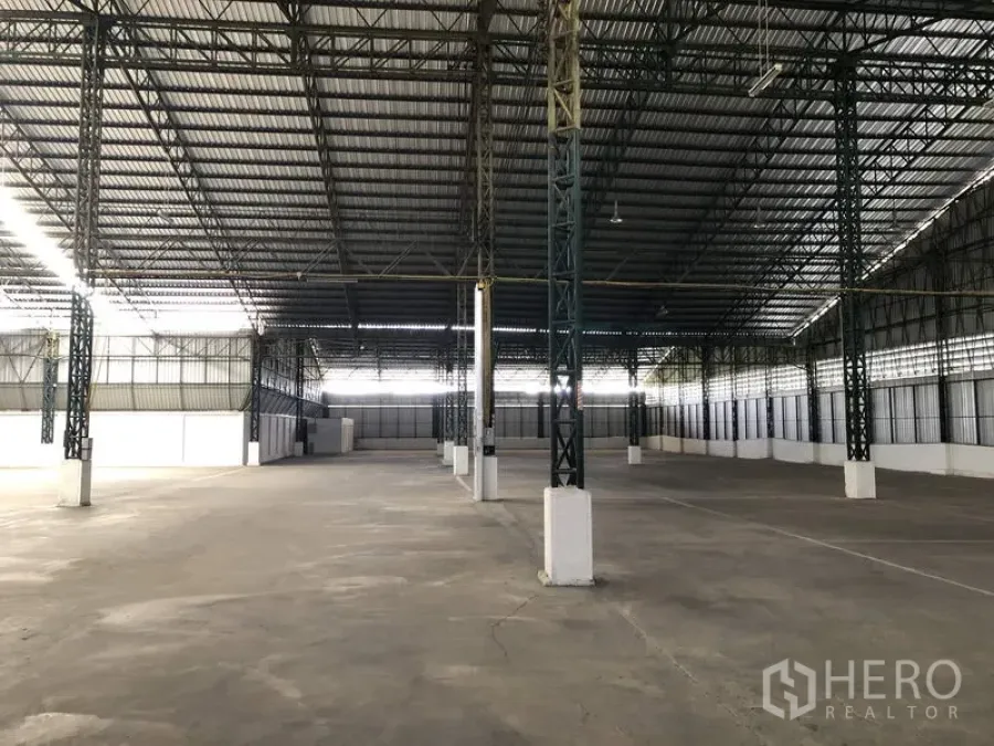 货栈 出租在Mueang Pathum Thani, Pathum Thani - 巴吞他尼直辖县宽敞仓库内部，高钢结构桁架屋顶、宽柱距与平整混凝土地面。