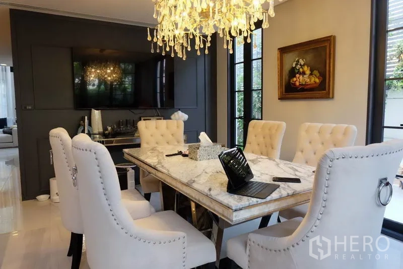 ทาวน์เฮาส์ ให้เช่าในKhlong Toei, Bangkok - ห้องทานอาหารหรู โต๊ะหินอ่อน เก้าอี้บุกระดุม และโคมไฟคริสตัลริมหน้าต่างบานใหญ่