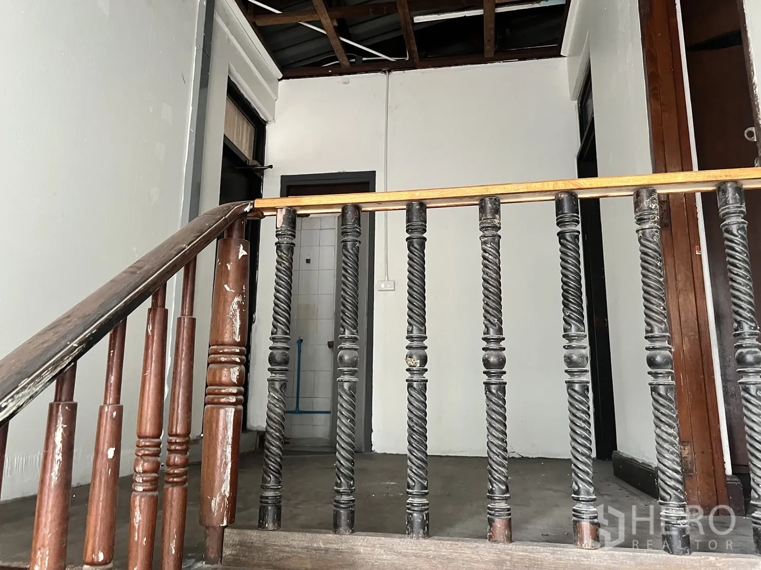 零售空间 出租在Watthana, Bangkok - 楼梯平台配装饰性木栏杆，部分天花外露。