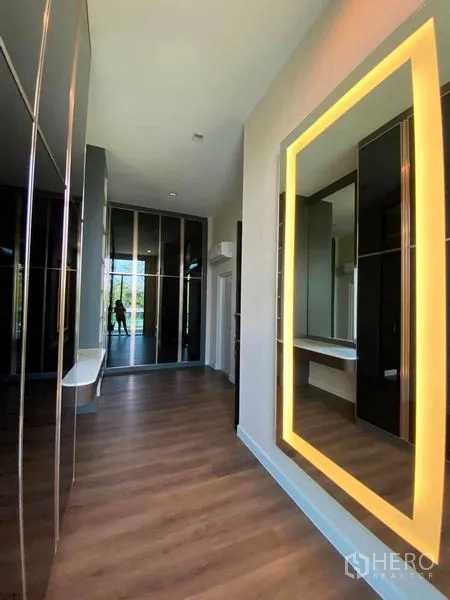 Detached House for sale in Don Mueang, Bangkok - Walk-in dressing area with backlit vanity mirror, floor-to-ceiling wardrobes and wood floors.