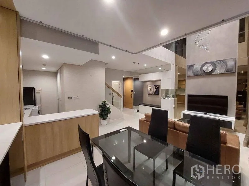 คอนโด ให้เช่าหรือขายในRatchathewi, Bangkok - โซนรับประทานอาหารข้างครัวเปิดในคอนโดดูเพล็กซ์สมัยใหม่