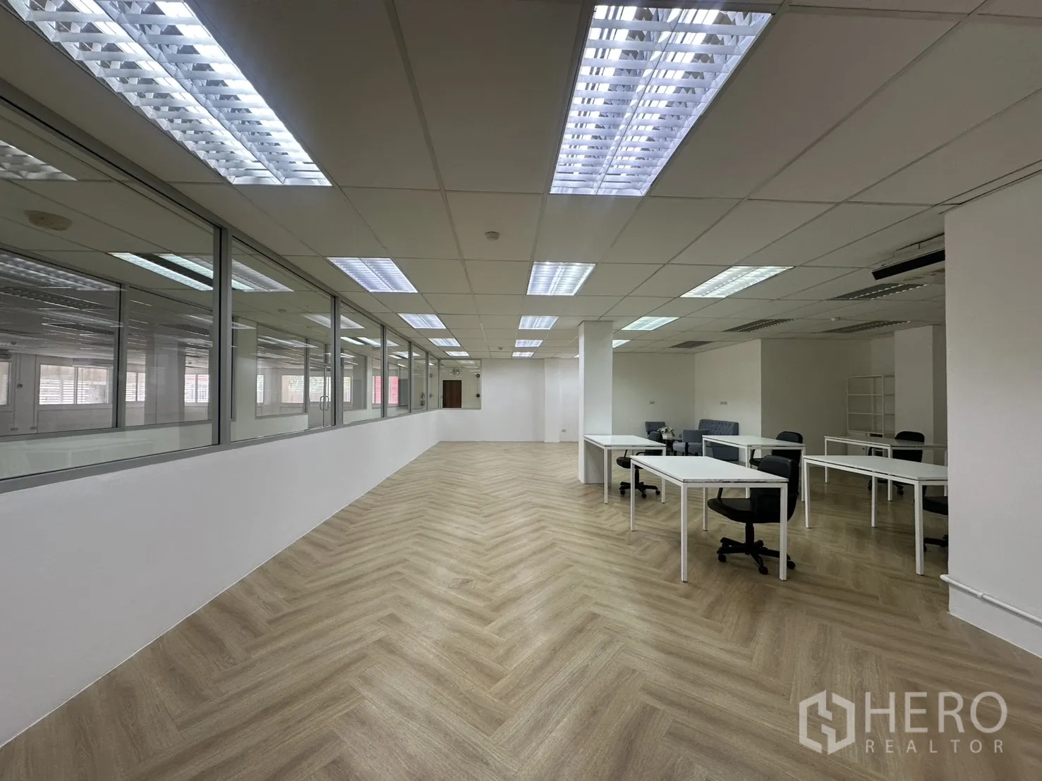 ออฟฟิศ for rent in Pathum Wan, Bangkok - ออฟฟิศแปลนเปิดพื้นลายก้างปลา เพดานกริดติดไฟ และผนังกระจกพร้อมโต๊ะทำงาน