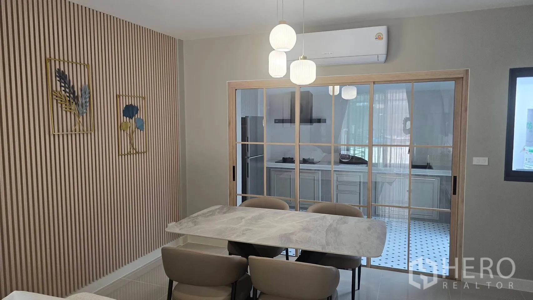 Townhouse for rent in Bang Phli, Samut Prakan - Contemporary dining area with pendant lights and sliding glass doors to the kitchen.