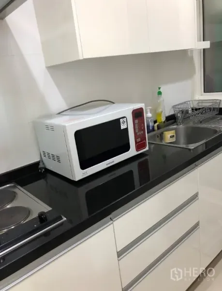 คอนโด ให้เช่าหรือขายในKhlong Toei, Bangkok - ครัวขนาดกะทัดรัดโทนขาว เคาน์เตอร์หินสีดำ อ่างล้างจาน ไมโครเวฟ และเตาไฟฟ้า