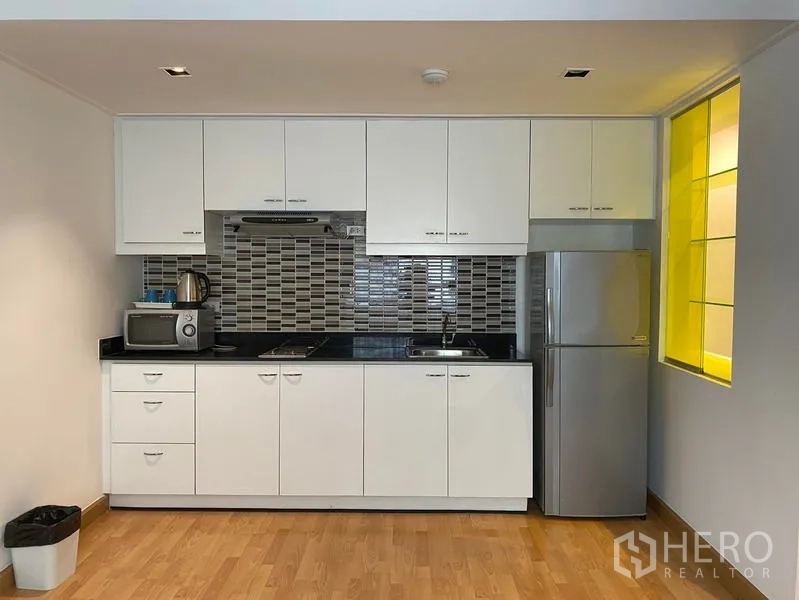 คอนโด ให้เช่าในKhlong Toei, Bangkok - ครัวบิวท์อินสีขาว ผนังโมเสค เตาไมโครเวฟ และตู้เย็นขนาดใหญ่