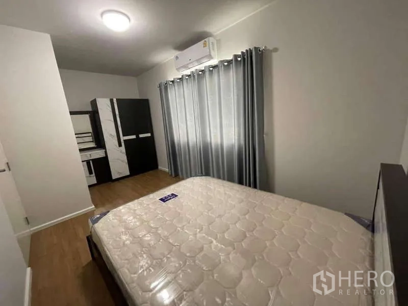 Townhouse for rent or sale in Phasi Charoen, Bangkok - Bedroom with large curtains, air-conditioning and fitted wardrobe.