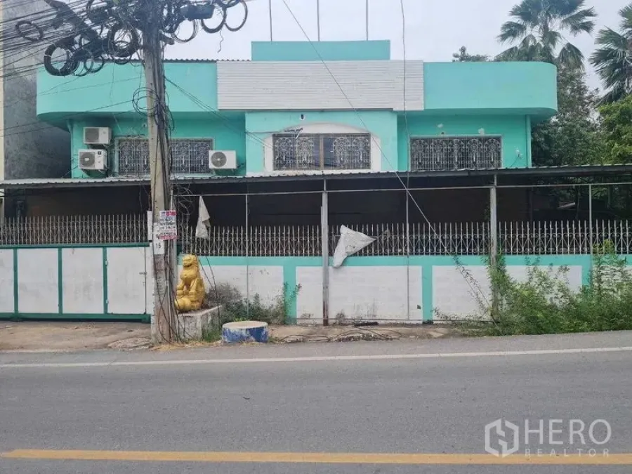 คลังสินค้า ให้เช่าในBang Yai, Nonthaburi - มุมมองด้านหน้า อาคารโกดังสองชั้นสีเขียวมิ้นท์ พร้อมรั้วติดถนน