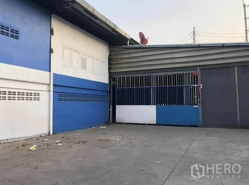 货栈 出租在Bang Phli, Samut Prakan - 仓库入口的装卸区，金属大门与多组卷闸门。