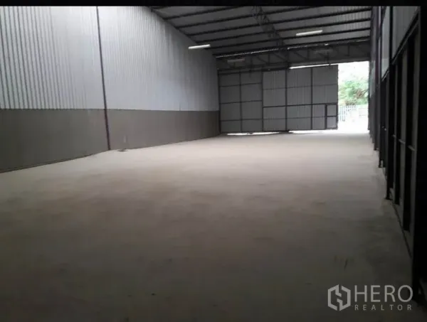 货栈 出租在Lam Luk Ka, Pathum Thani - 空旷仓库地面，金属夹芯墙体，远端大型出入口与自然采光