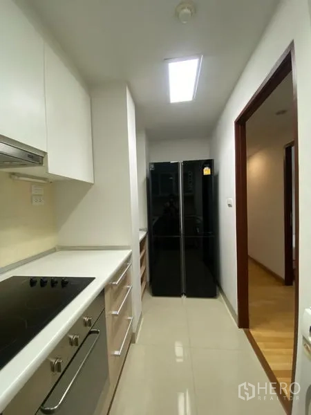 คอนโด ให้เช่าหรือขายในKhlong Toei, Bangkok - โถงครัวมีตู้เย็นประตูคู่ ตู้เก็บของจำนวนมาก และแสงสว่างเพียงพอ