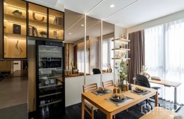 Condominium for sale in Watthana, Bangkok - Bright dining area with mirrored wall, built-in shelves and a wine fridge in a modern Thonglor condo