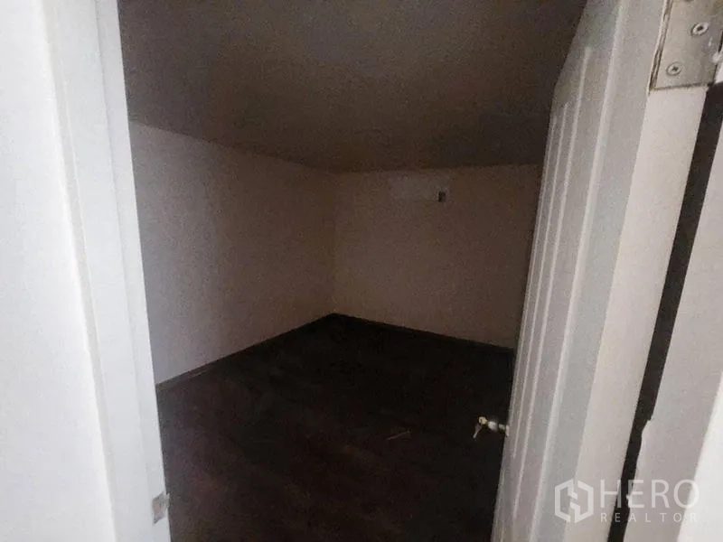 Warehouse for rent in Suan Luang, Bangkok - Small enclosed storage room with a low ceiling and dark flooring.