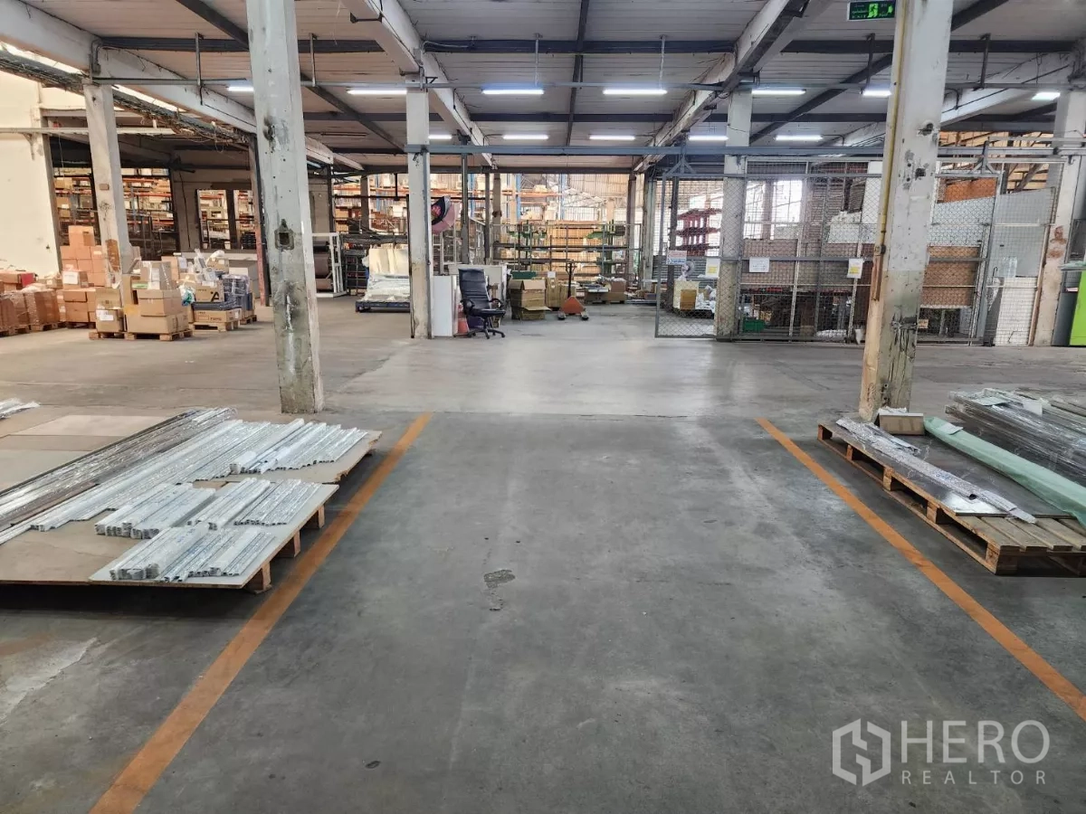 工厂 出租在Mueang Samut Sakhon, Samut Sakhon - 工业存储区，有柱网、货架与托盘材料。