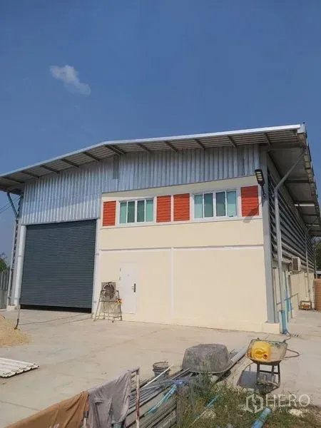 Warehouse for rent in Lam Luk Ka, Pathum Thani - Modern steel-frame warehouse exterior with wide roller shutter and loading apron in Lam Luk Ka.
