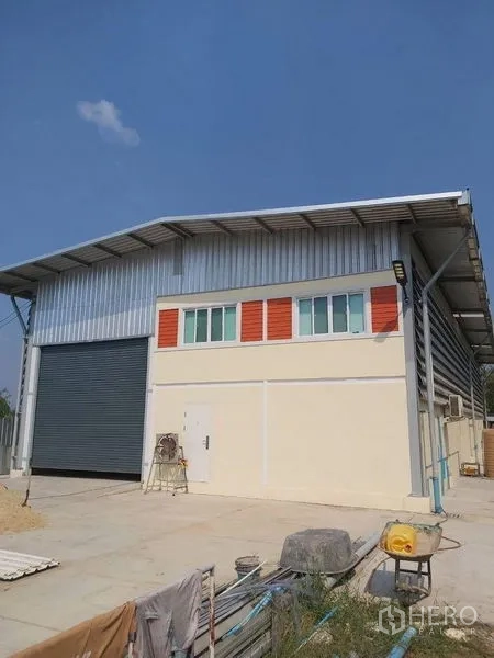 Warehouse for rent in Lam Luk Ka, Pathum Thani - Modern steel-frame warehouse exterior with wide roller shutter and loading apron in Lam Luk Ka.