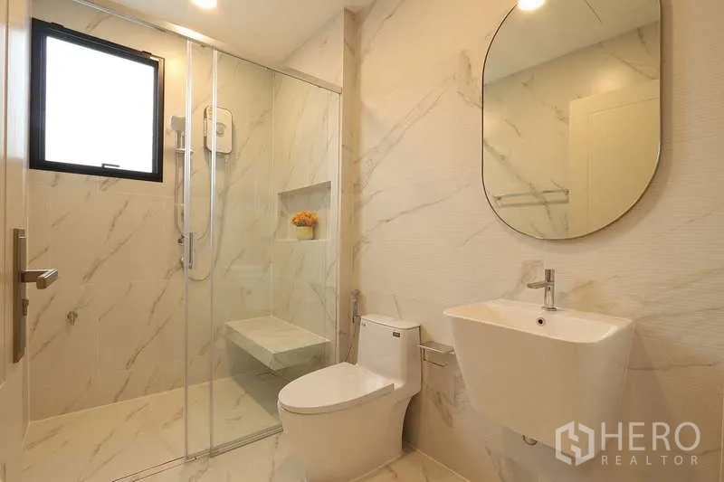 บ้าน ให้เช่าในSaphan Sung, Bangkok - ห้องน้ำสมัยใหม่ ปูกระเบื้องลายหินอ่อน มีตู้กระจกกั้นอาบน้ำ โถสุขภัณฑ์ และอ่างล้างหน้าแบบแขวน