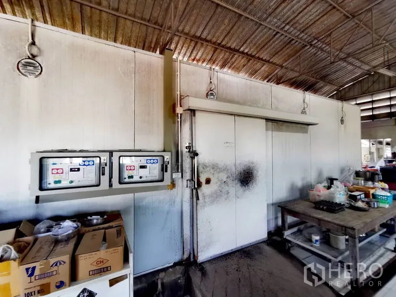 货栈 出售在Pathum Thani - 仓库内的冷库房，带推拉门、控制面板与工作台。