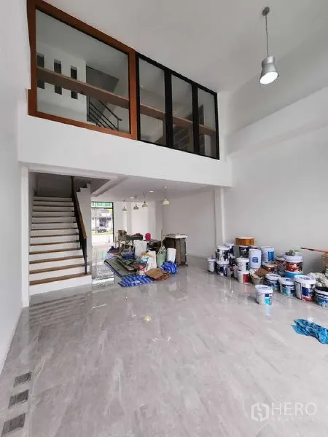 带办公室的家 出租在Prawet, Bangkok - 现代商住两用办公楼的挑高大堂与夹层，楼梯与亮面瓷砖地面，正在轻度整修。