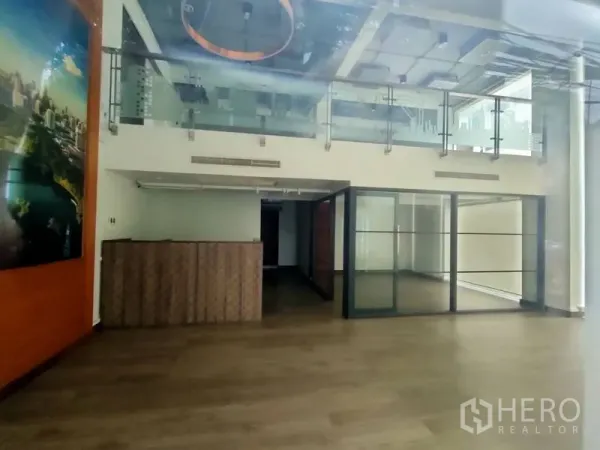 办公空间 出租在Pathum Wan, Bangkok - 阁楼风格办公内景，带夹层、玻璃扶手、木地板、接待台和玻璃隔断会议室