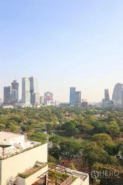 Condominium for rent in Pathum Wan, Bangkok - High-floor view of the Bangkok skyline and a large green park with a lake.