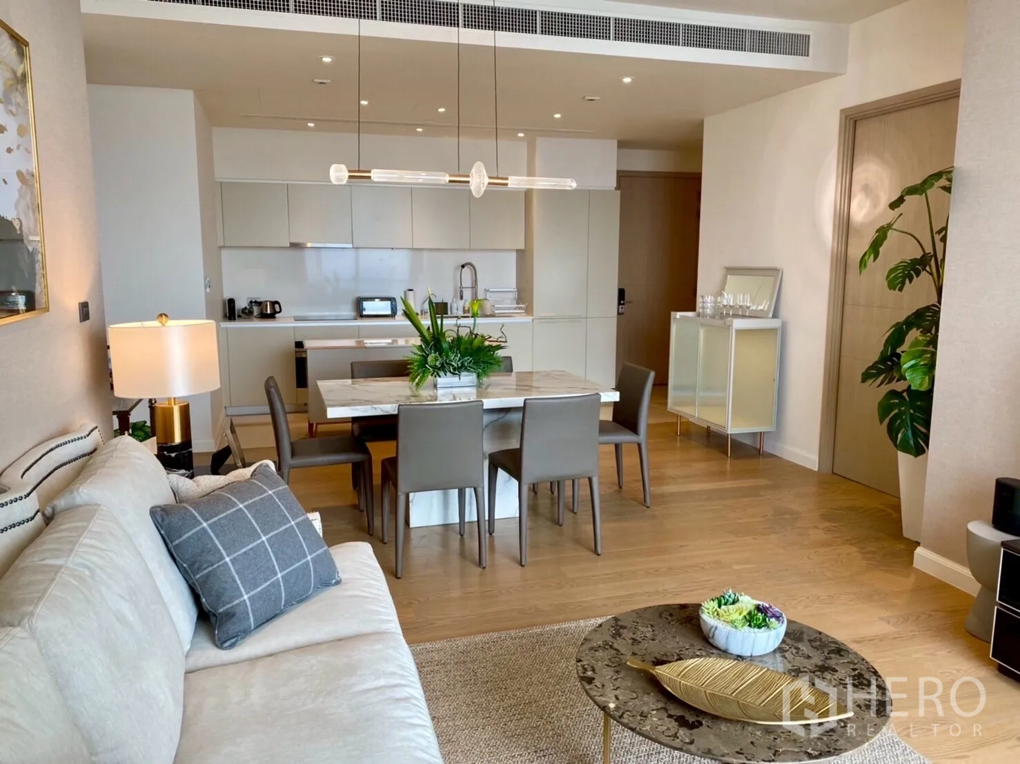 คอนโด ให้เช่าในKhlong San, Bangkok - ห้องนั่งเล่นแบบเปิดโล่งเชื่อมพื้นที่ทานอาหารและครัวสีขาว พร้อมโคมไฟแขวน