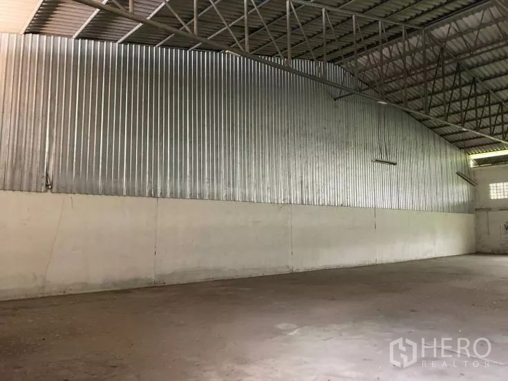 Factory for rent in Bang Phli, Samut Prakan - Warehouse interior showing corrugated metal wall cladding and tall trussed ceiling.