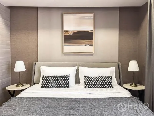 Condominium for rent in Pathum Wan, Bangkok - Cozy bedroom with a king bed, twin bedside lamps, and framed artwork above the headboard.