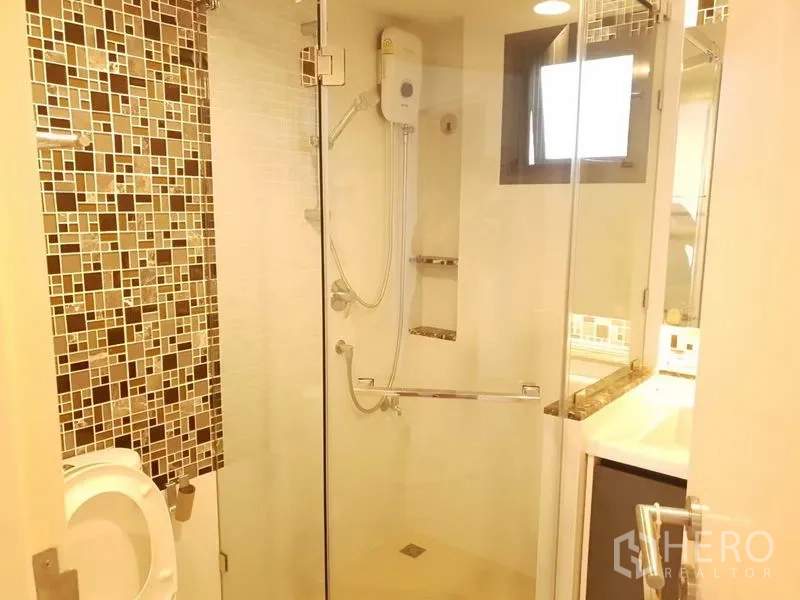 บ้าน ให้เช่าในBang Kapi, Bangkok - ห้องน้ำพร้อมตู้อาบน้ำกระจก ผนังกระเบื้องโมเสก และเครื่องทำน้ำอุ่น.