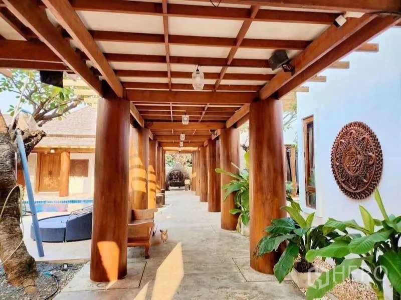 Detached House for sale in Bueng Kum, Bangkok - Veranda walkway with round timber columns beside the pool and garden.